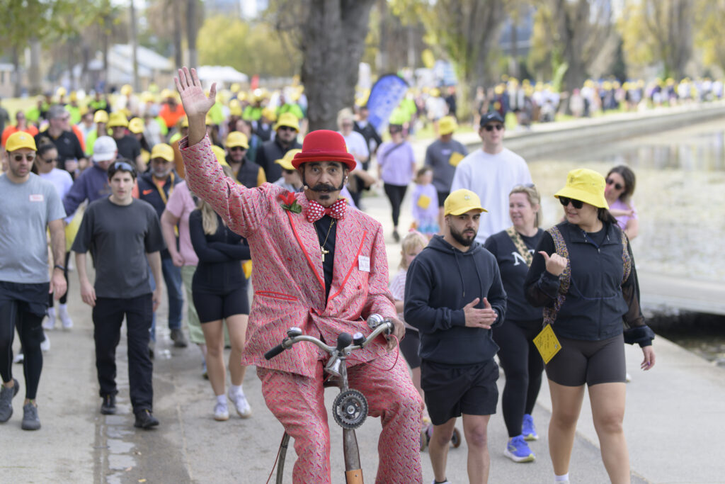 People walking to support Shine a Light on Road Safety Walk & Wheel event, wearing yellow to raise awareness and honour those affected by road trauma. 